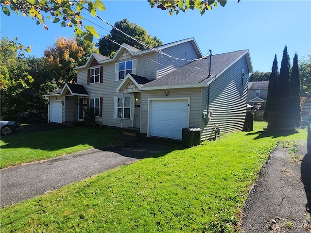 view of property featuring a front lawn and a garage