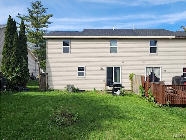 rear view of property featuring a lawn and a wooden deck