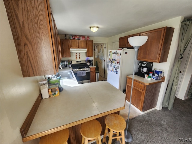 kitchen with light colored carpet, kitchen peninsula, stainless steel range, a breakfast bar area, and white fridge