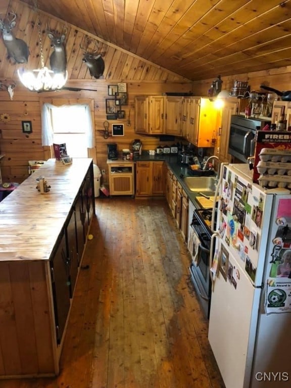 kitchen featuring white refrigerator, lofted ceiling, wood walls, wood ceiling, and dark hardwood / wood-style floors