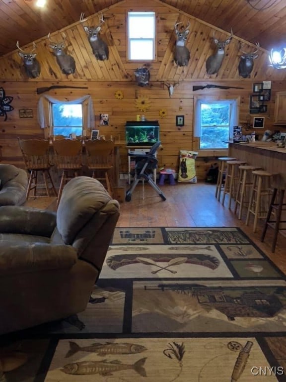 living room with wood-type flooring, wooden walls, wood ceiling, and high vaulted ceiling