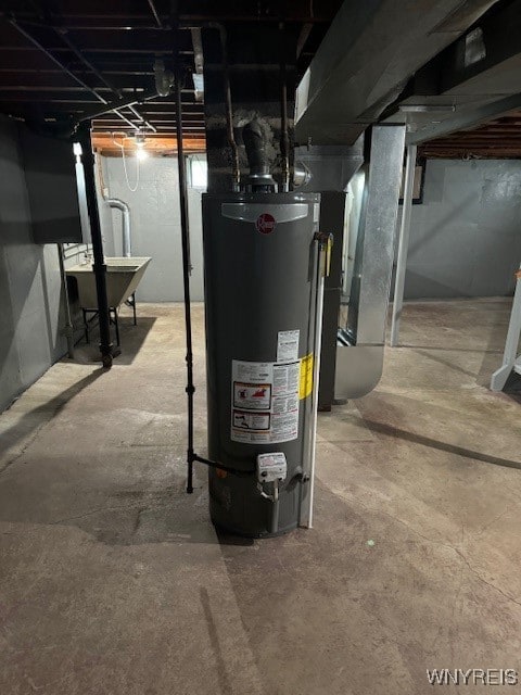 utility room featuring gas water heater and sink