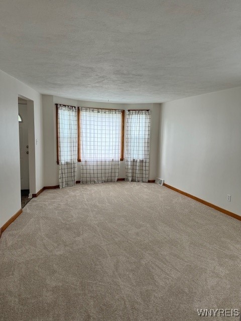 carpeted spare room with a textured ceiling