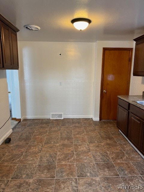 kitchen featuring dark brown cabinets and sink