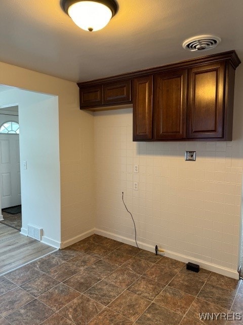 laundry room with cabinets and tile walls