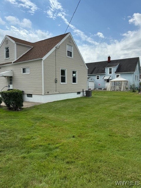 back of house featuring a lawn and central AC unit