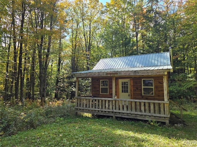 view of outdoor structure featuring a lawn and a porch