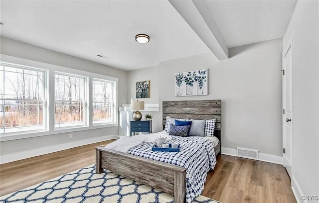 bedroom featuring visible vents, baseboards, and wood finished floors