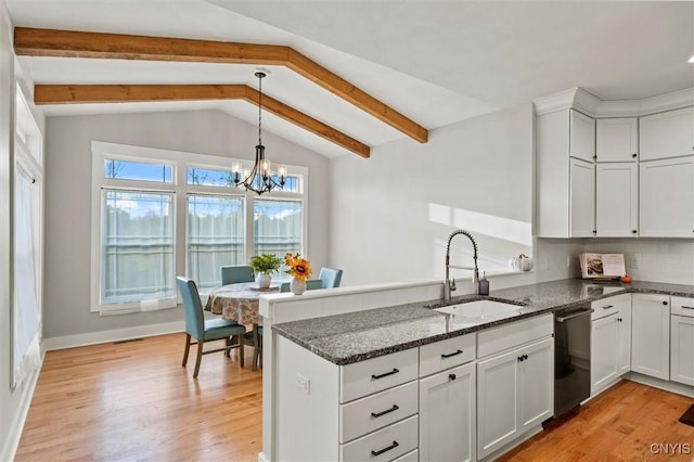 kitchen featuring black dishwasher, dark stone countertops, a sink, and white cabinetry