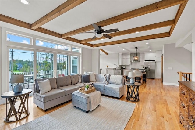 living area featuring a ceiling fan, recessed lighting, beamed ceiling, and light wood-style flooring