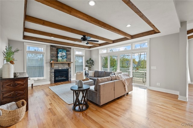 living area featuring plenty of natural light, a fireplace, light wood-style flooring, and baseboards