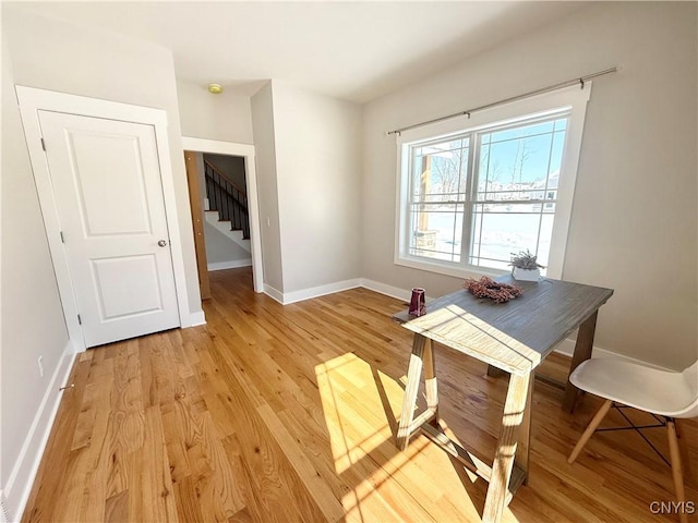 dining space featuring light wood-type flooring and baseboards