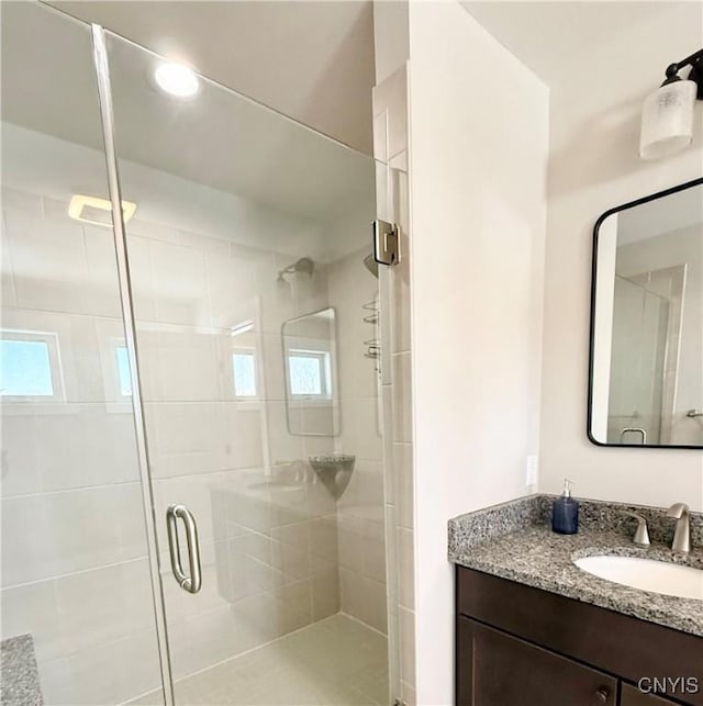 full bathroom featuring a stall shower and vanity