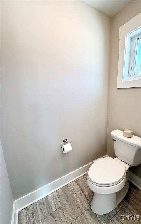 bathroom featuring wood finished floors, toilet, and baseboards