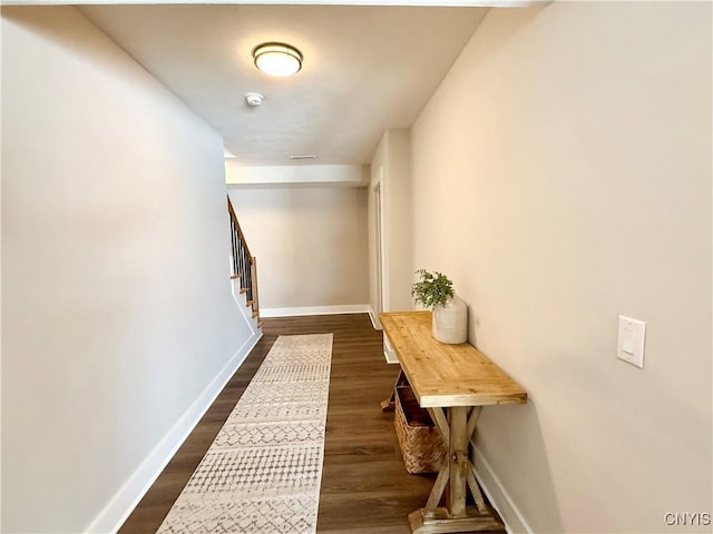 corridor with baseboards, visible vents, stairway, and dark wood finished floors