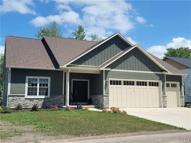 craftsman house with a front lawn and a garage