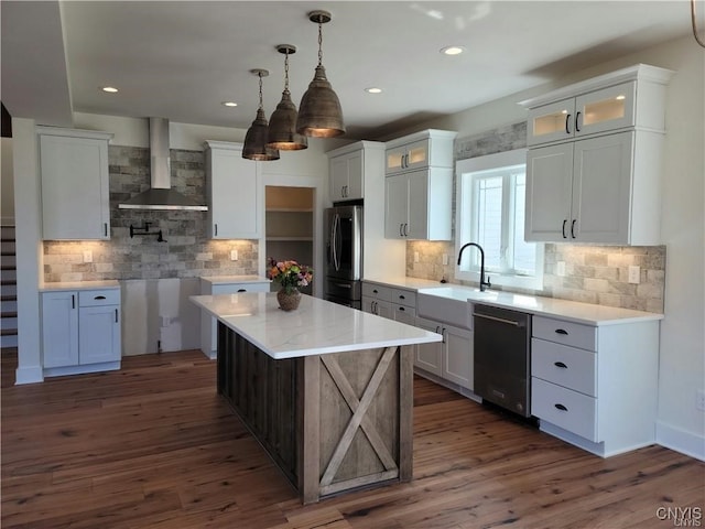 kitchen with appliances with stainless steel finishes, wall chimney range hood, and white cabinetry