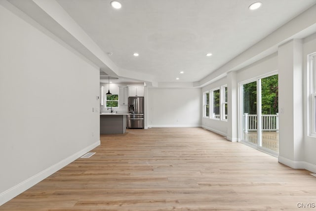 unfurnished living room featuring light hardwood / wood-style floors and sink