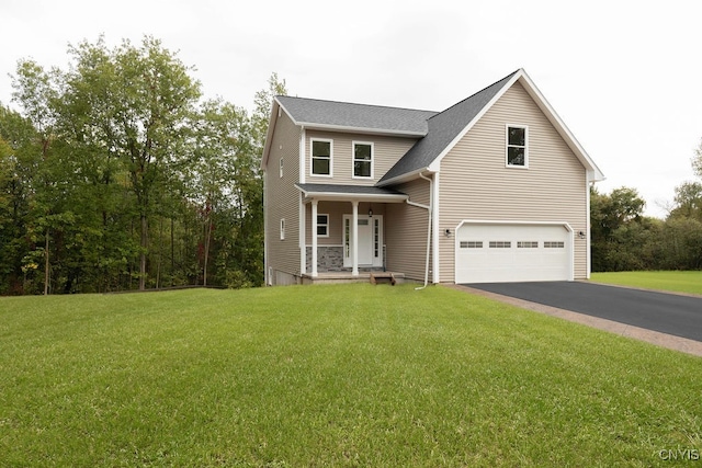 view of front of house featuring a front yard, a garage, and covered porch