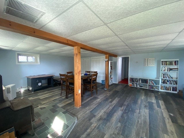 basement with a paneled ceiling and dark hardwood / wood-style flooring