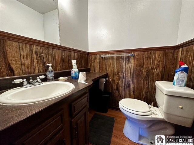 3682 Rte 430, Ellery, NY 14712 - bathroom featuring vanity, toilet, a wainscoted wall, wooden walls, and wood finished floors