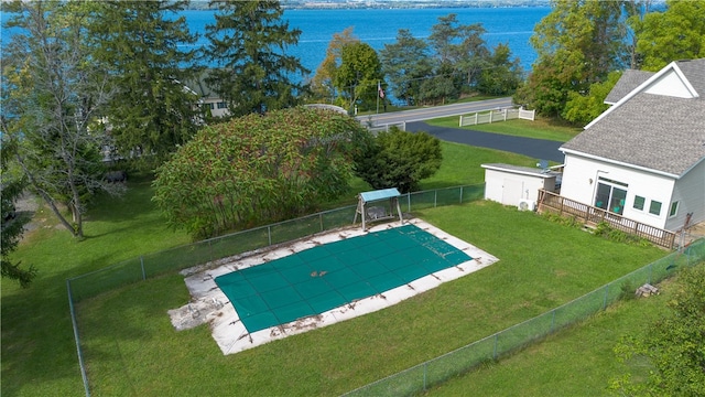 view of swimming pool featuring a lawn and a water view