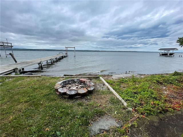 view of dock featuring a fire pit and a water view