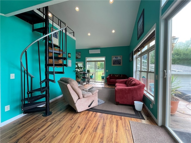 living room with wood-type flooring, vaulted ceiling, and an AC wall unit