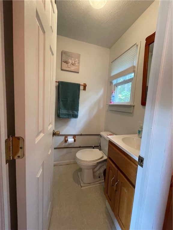 bathroom featuring a textured ceiling, vanity, and toilet