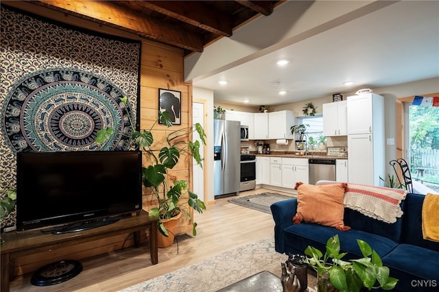 living room with light hardwood / wood-style flooring and beam ceiling