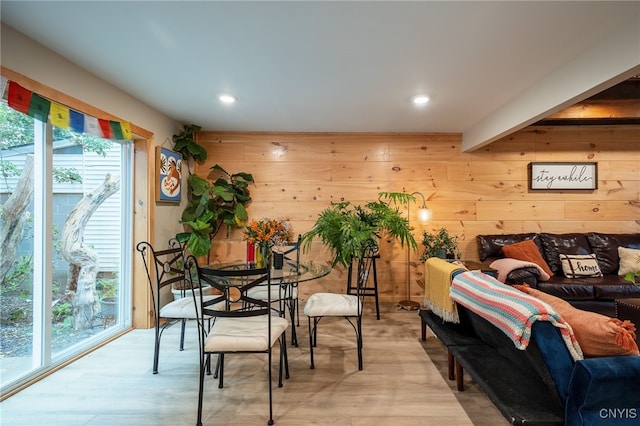 dining room featuring light hardwood / wood-style flooring and wooden walls