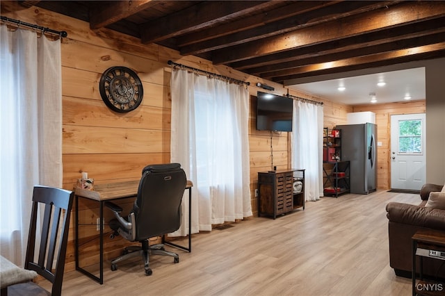 office featuring light wood-type flooring, wooden walls, and beamed ceiling