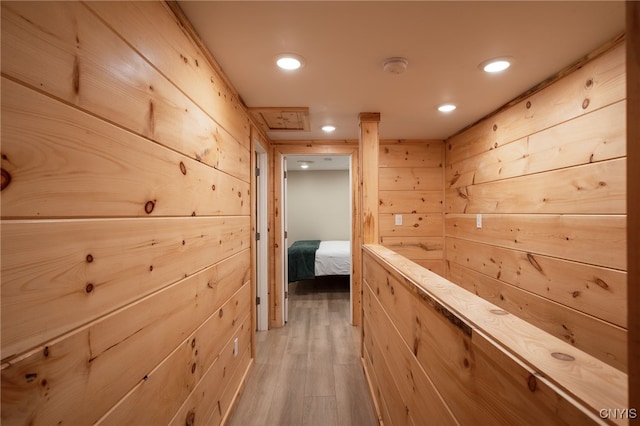 hall featuring wood walls and light hardwood / wood-style floors