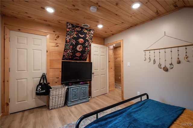 bedroom with wooden ceiling, light hardwood / wood-style floors, and wooden walls