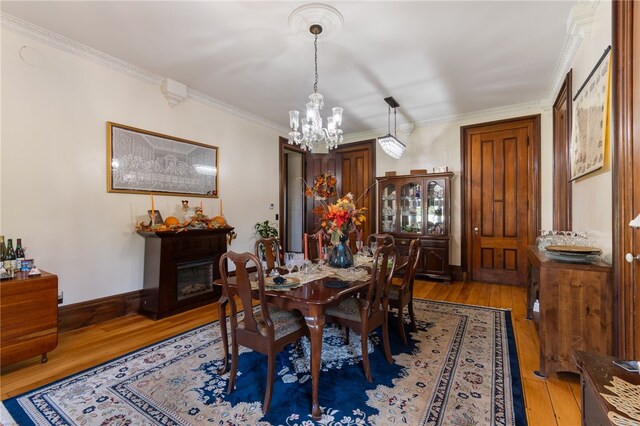 dining room featuring crown molding, hardwood / wood-style floors, and a notable chandelier