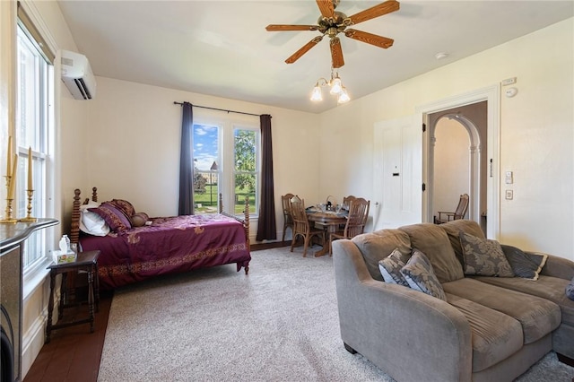bedroom featuring a wall mounted AC and ceiling fan