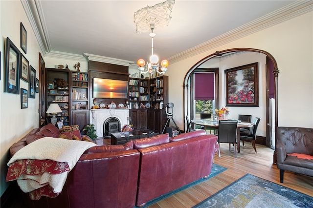 living room with a notable chandelier, ornamental molding, and hardwood / wood-style flooring