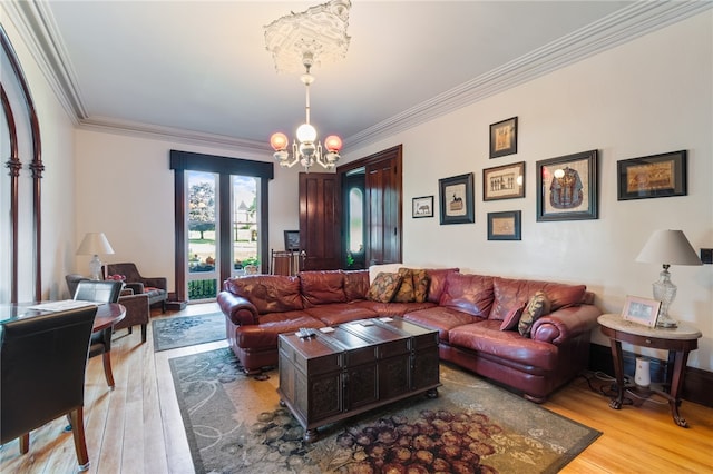 living room featuring crown molding, light hardwood / wood-style flooring, and a notable chandelier