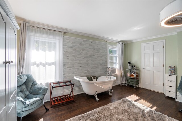 sitting room featuring cooling unit, crown molding, dark wood-type flooring, and a wealth of natural light