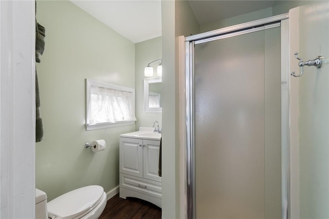 full bath featuring vanity, toilet, baseboards, a stall shower, and wood finished floors