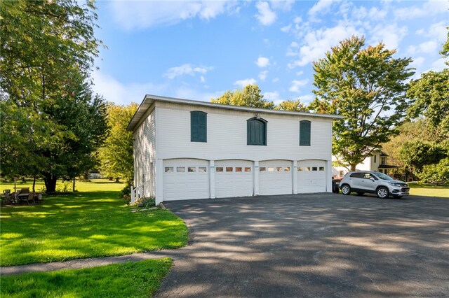 view of side of home featuring a lawn and a garage