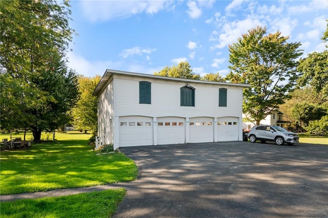 view of home's exterior featuring aphalt driveway, a yard, and an attached garage