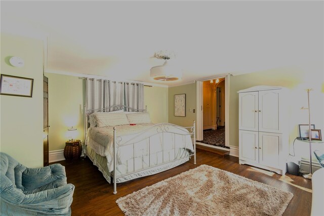 bedroom with ornamental molding and dark wood-type flooring