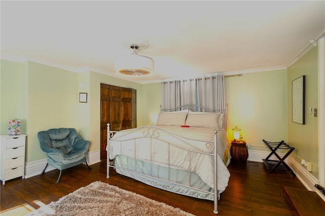 bedroom with ornamental molding and dark hardwood / wood-style floors