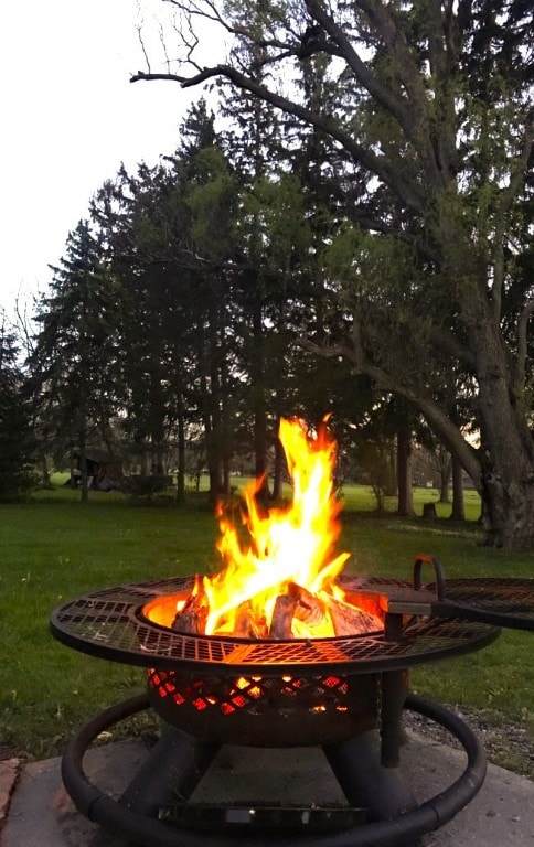 view of property's community with a lawn and an outdoor fire pit