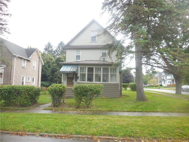 front facade with a sunroom and a front lawn