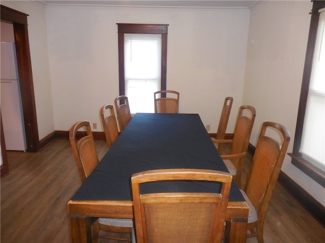 dining space featuring crown molding and dark hardwood / wood-style flooring