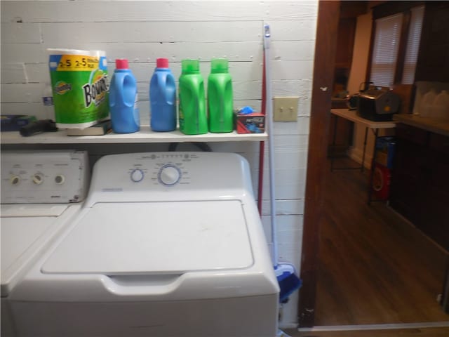 clothes washing area featuring wooden walls and independent washer and dryer