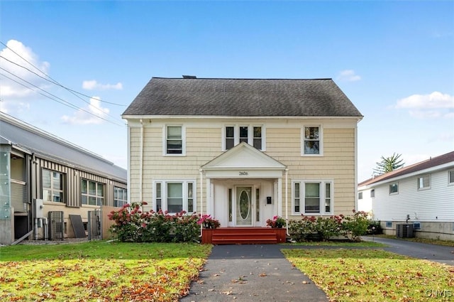 view of front of property with a front lawn and cooling unit