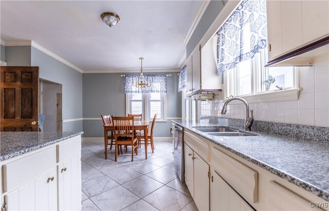 kitchen with white cabinets, sink, hanging light fixtures, stainless steel dishwasher, and crown molding